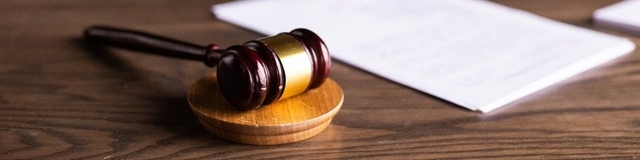 Alt-text: Advogado analisando documentos jurídicos em uma tela de computador, em um ambiente de escritório moderno.